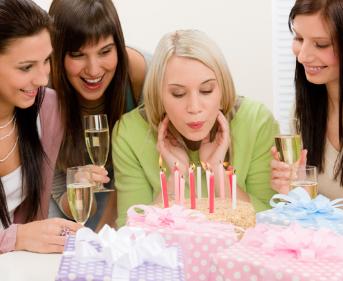 Woman Blowing Out Cake Candles